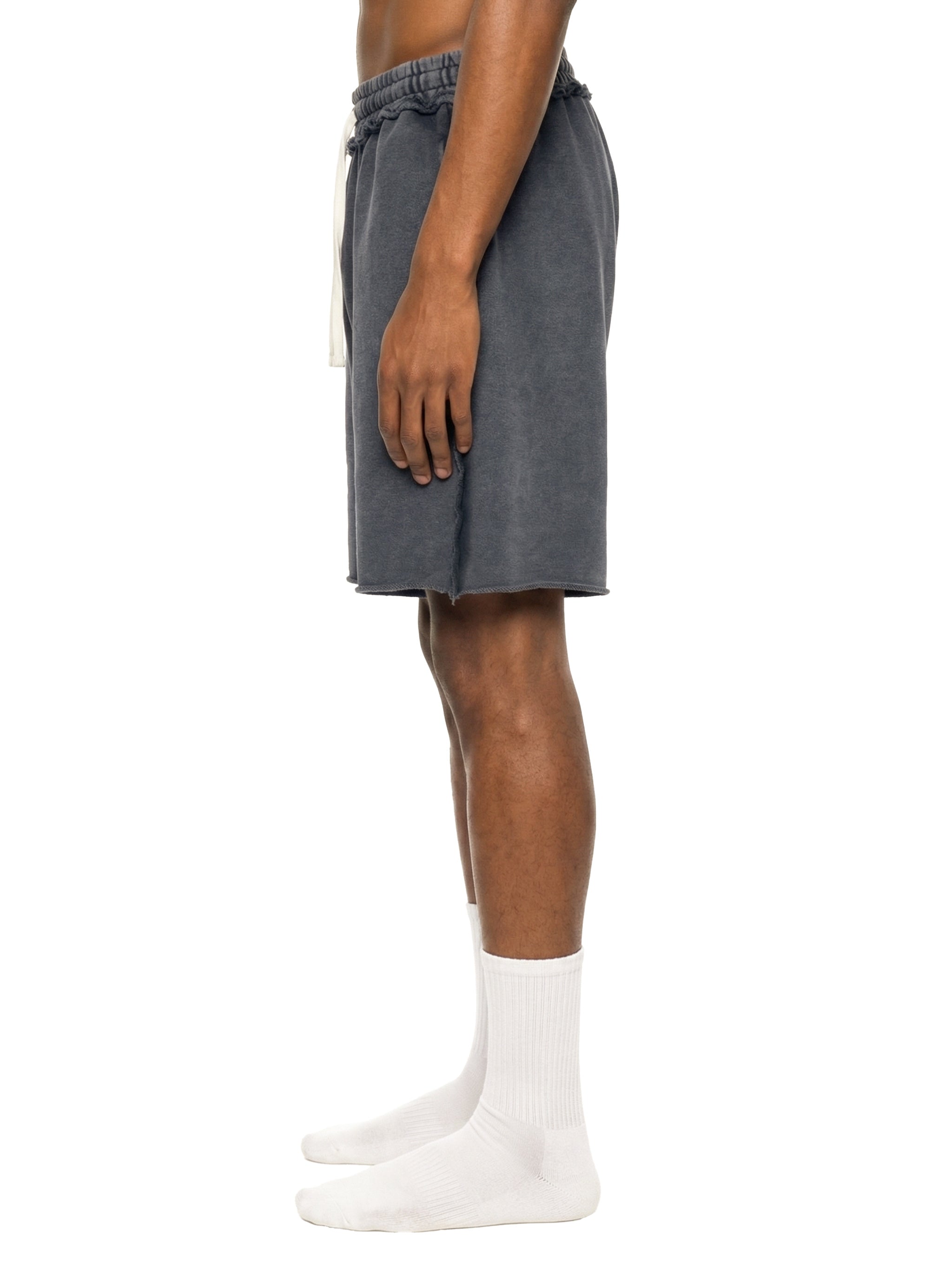 Person wearing gray shorts and white socks on a white background